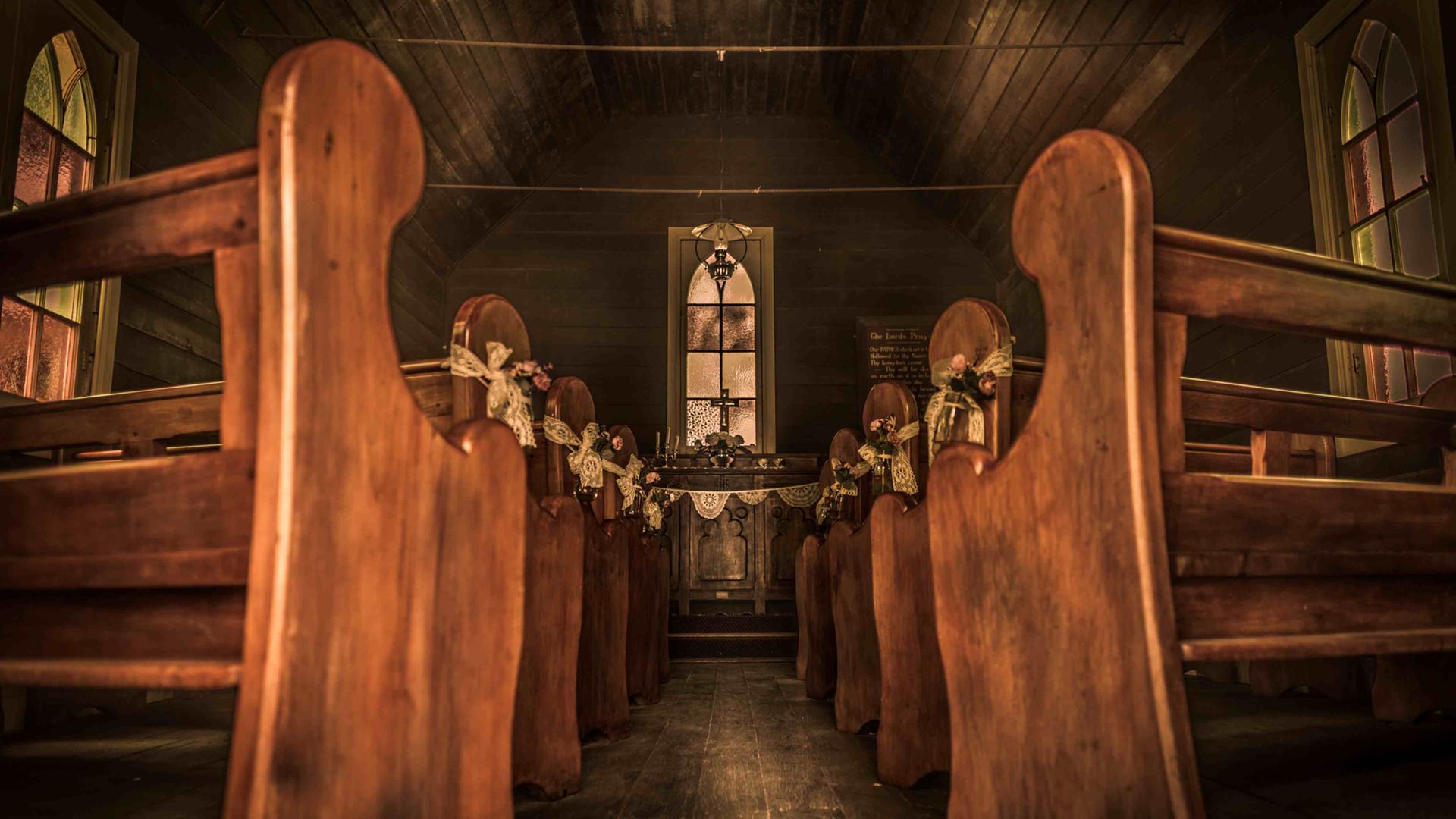 Blick entlang des leeren Gangs einer hölzernen Siedlerkirche zum Altar. Blick entlang des leeren Gangs einer hölzernen Siedlerkirche zum Altar.