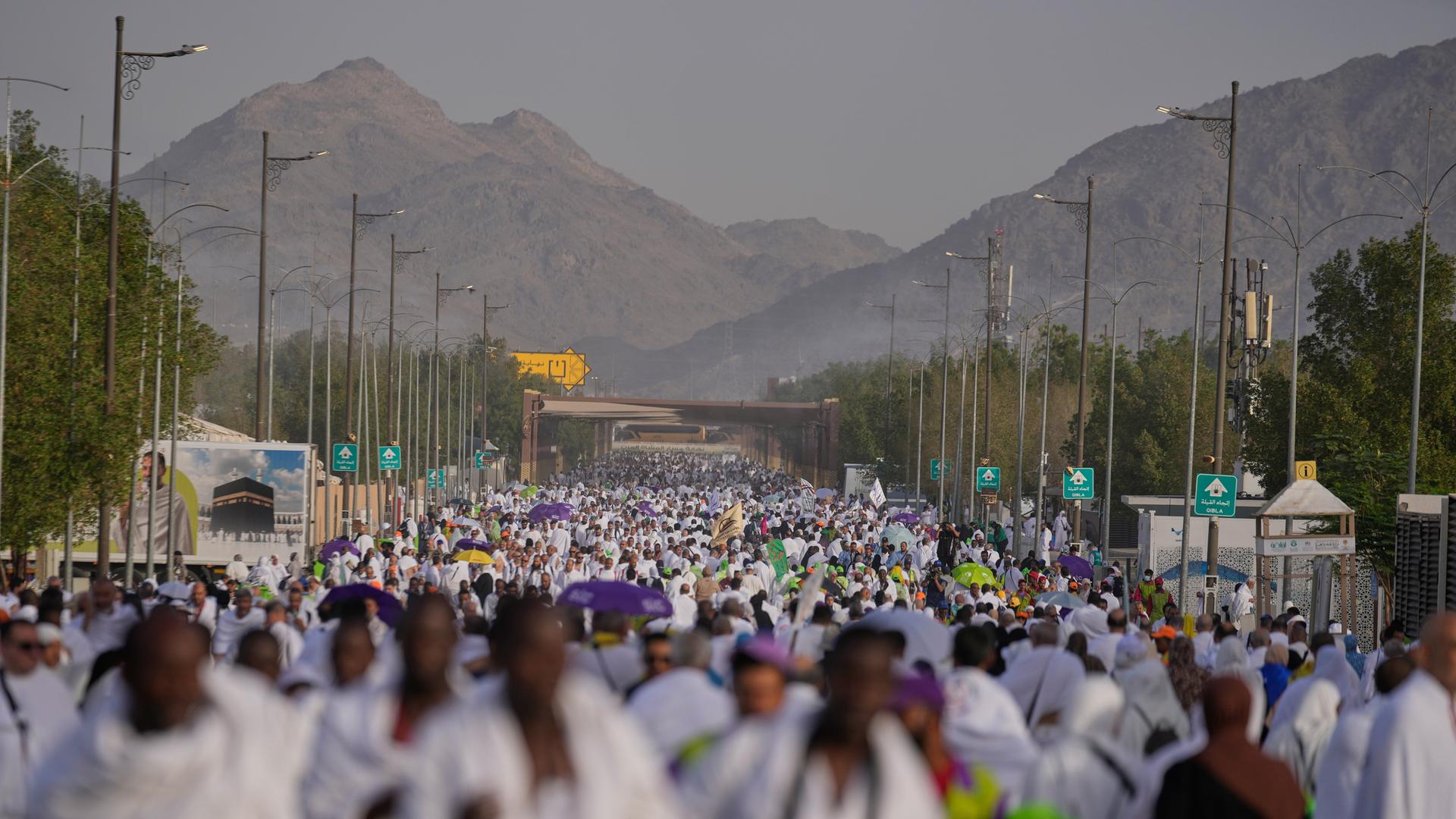 Saudi-Arabien, Mekka: Muslimische Pilger gehen während der jährlichen Hadsch-Pilgerfahrt in der Nähe der heiligen Stadt Mekka auf den als Berg der Barmherzigkeit bekannten Felsen in der Ebene von Arafat zu.