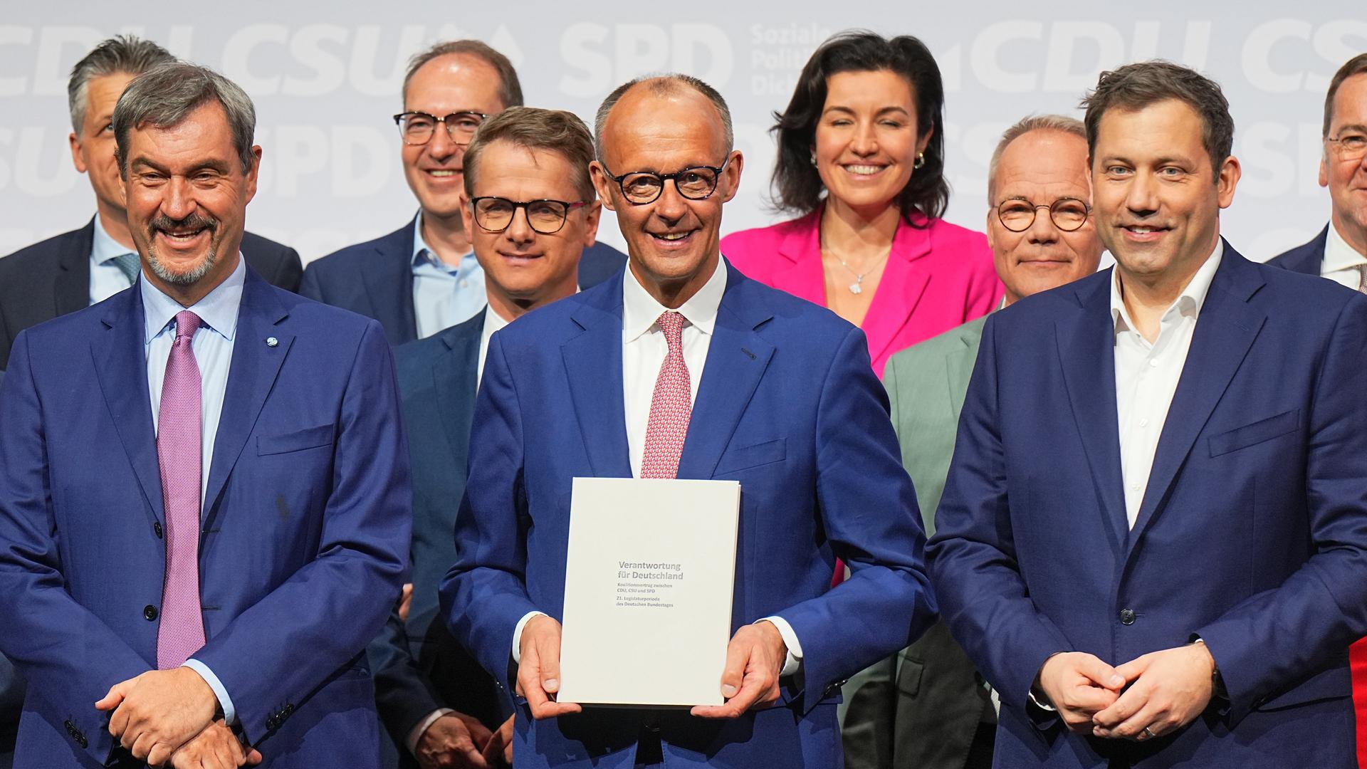 Die Chefs von den Parteien CSU, CDU und SPD stehen im Vordergrund. Dahinter sind einige Ministerinnen und Minister von der neuen Bundes-Regierung zu sehen. Die Chefs von den Parteien CSU, CDU und SPD stehen im Vordergrund. Dahinter sind einige Ministerinnen und Minister von der neuen Bundes-Regierung zu sehen.