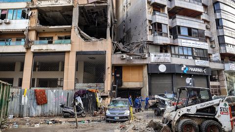 Das zerstörte Haus in Beirut, in dem der Hamas-Amführer ums Leben kam. Auf der Straße liegen Trümmer, einige Männer räumen sie mit Schaufeln fort.