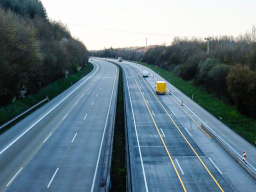 Blick auf eine leere Autobahn von oben, einzig ein DHL-Fahrzeug und zwei weitere Transporter sind zu sehen