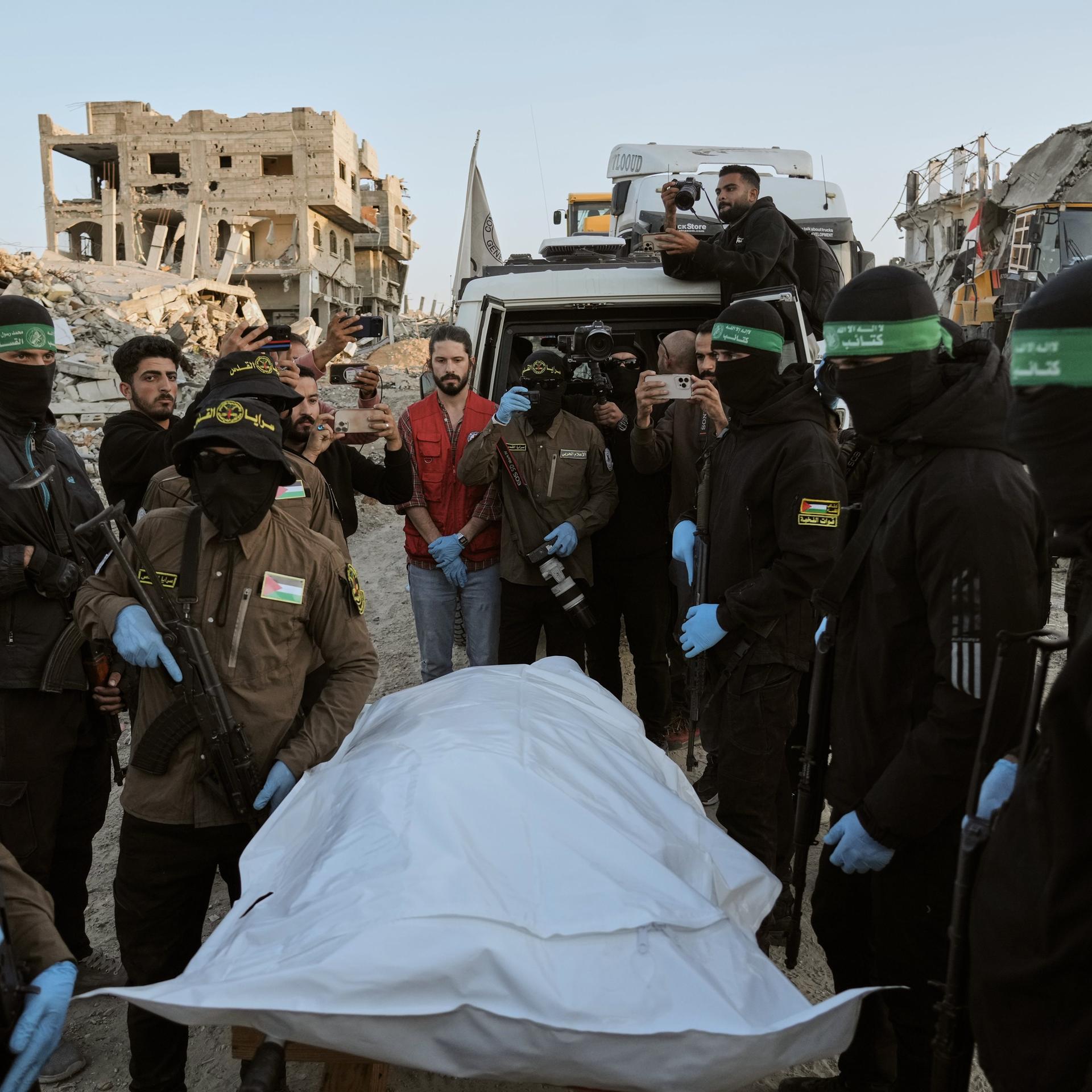 Beit Lahiya: Maskierte Kämpfer des Islamischen Dschihad und der Hamas übergeben im nördlichen Gazastreifen einen Leichensack an das Rote Kreuz zur Übergabe an israelische Behörden.