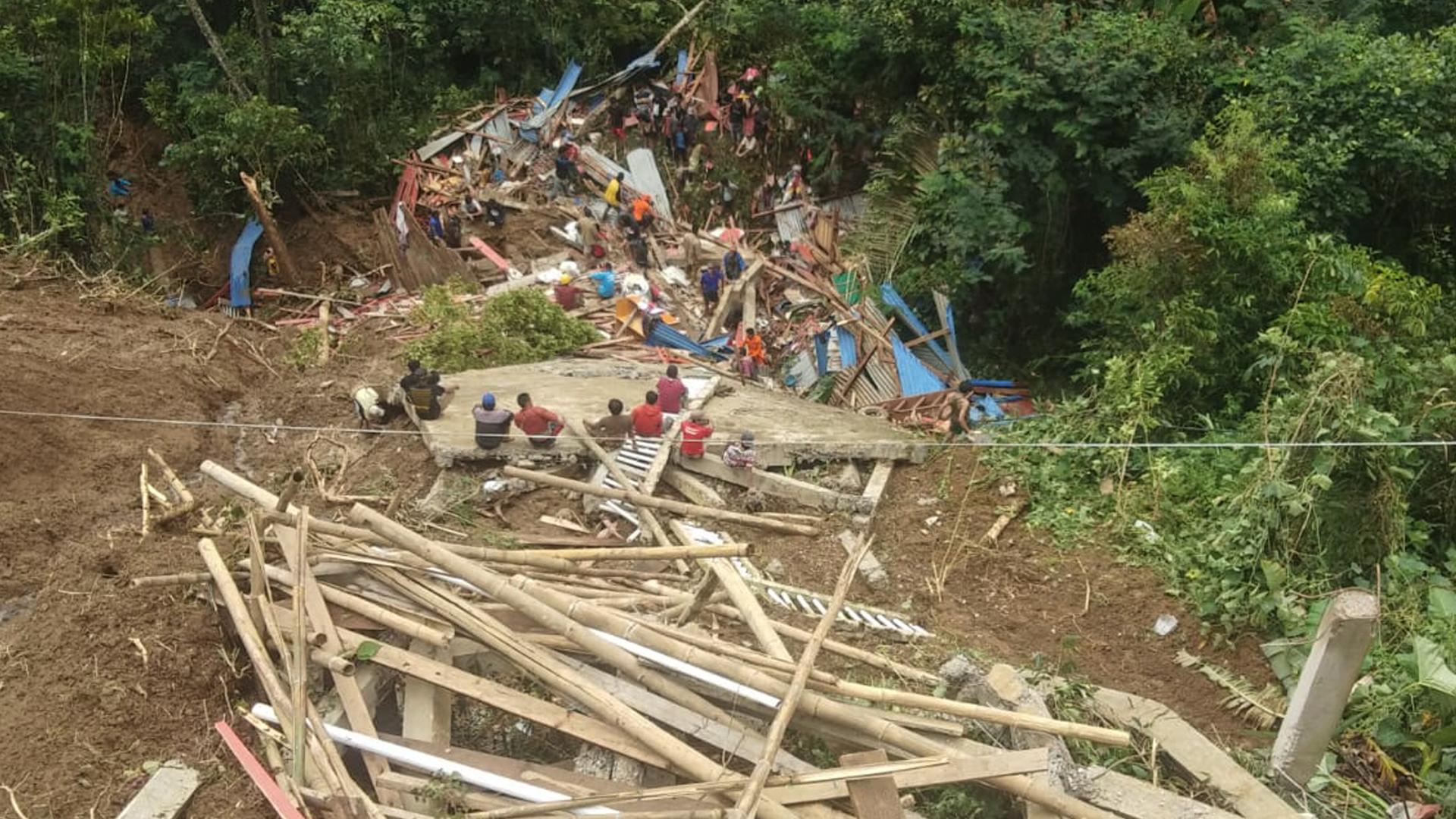 Die indonesischen Rettungskräfte versuchen, weitere Opfer zu finden. Sie durchsuchen das Hochland bei Tana Toraja, Süd-Sulawesi. Davor sind Trümmer zu sehen.