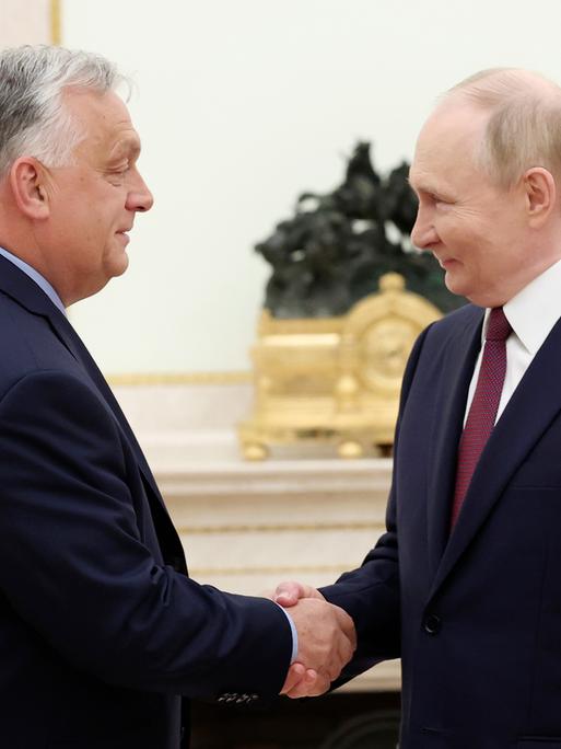 Viktor Orban und Wladimir Putin schütteln Hände