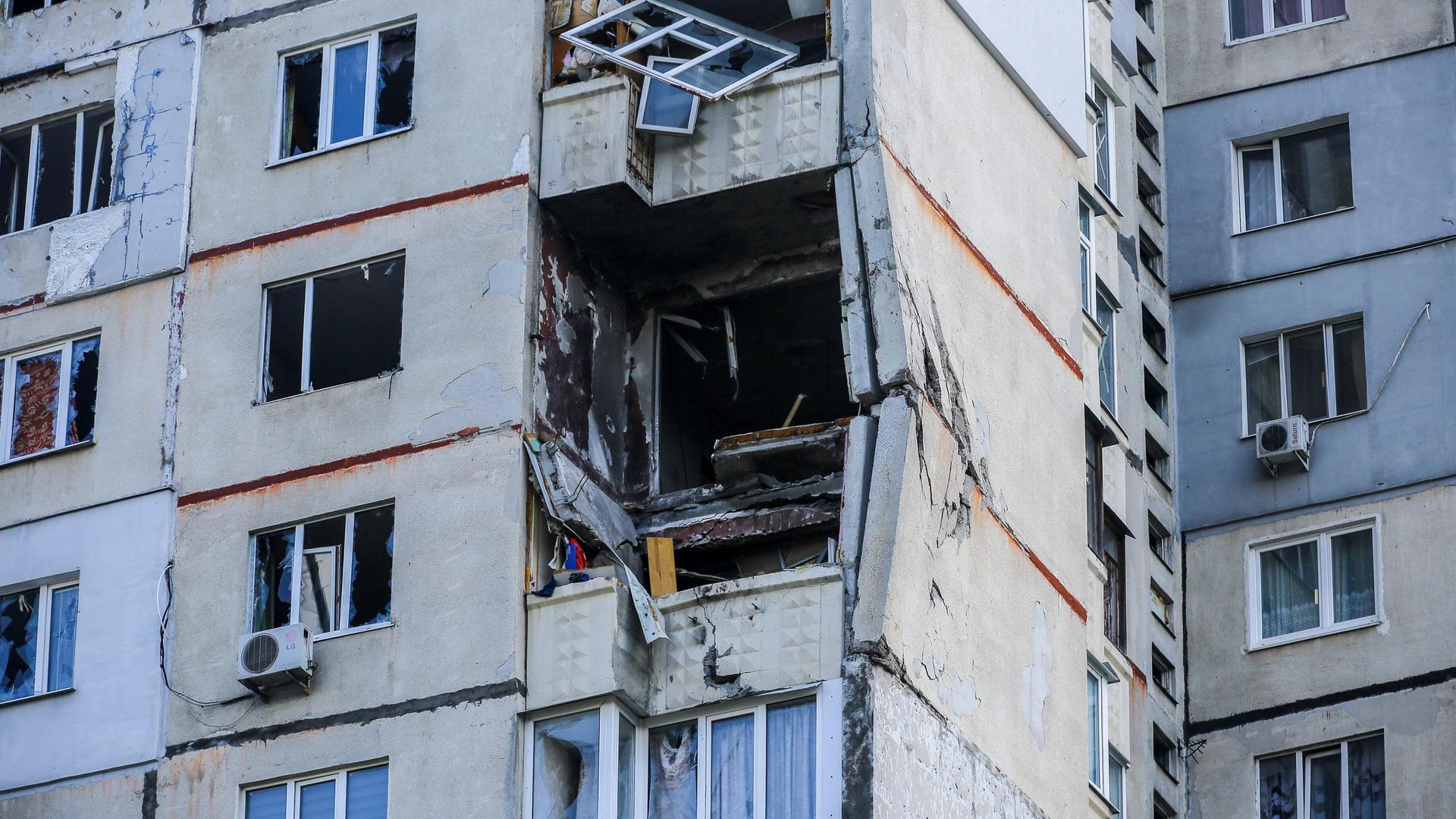 An einem Wohnhaus in Charkiw sind Fenster und Balkone teilweise zerstört. 
