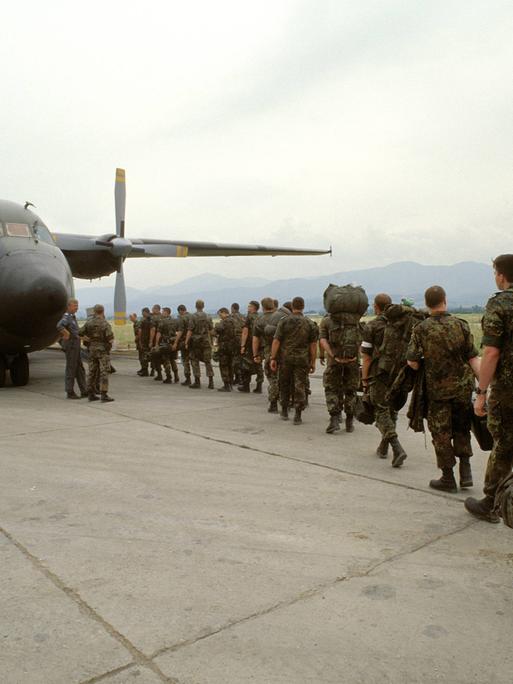 Angehörige der Bundeswehr steigen während des Einsatzes im Grenzgebiet Kosovo - Mazedonien Ende der 1990er Jahre in ein Transportflugzeug.