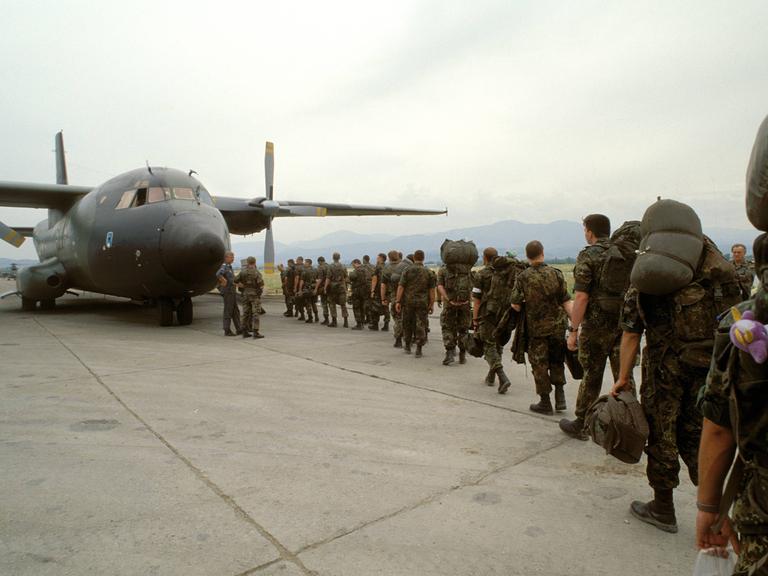 Angehörige der Bundeswehr steigen während des Einsatzes im Grenzgebiet Kosovo - Mazedonien Ende der 1990er Jahre in ein Transportflugzeug.