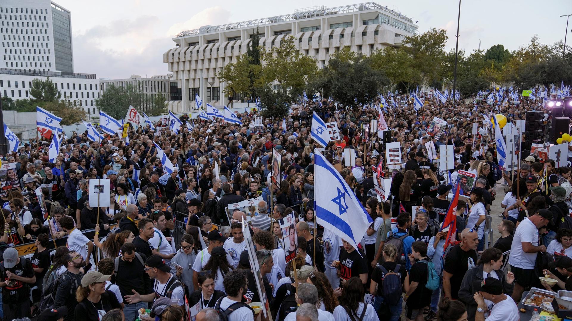Ein Protestzug mit tausenden Teilnehmern versammelt sich vor einem großen Gebäude, in der Menge werden viele Israel-Flaggen geschwenkt.