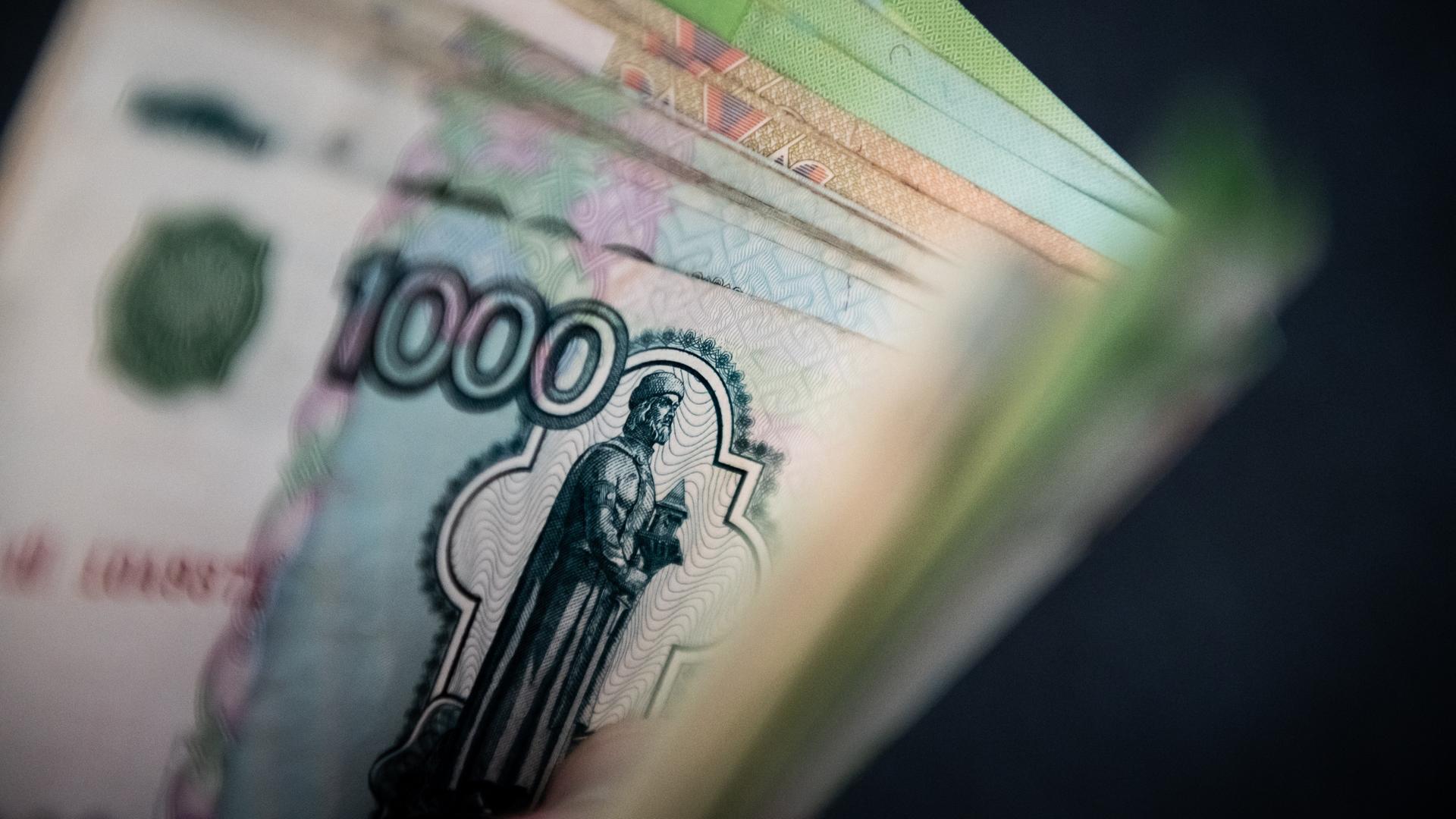 Ein Mann hält Rubelscheine in der Hand Ein Mann hält Rubelscheine in der Hand