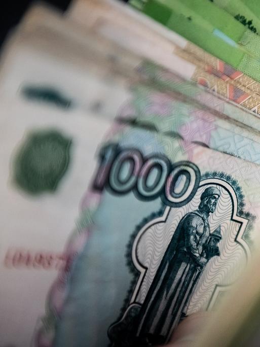 Ein Mann hält Rubelscheine in der Hand