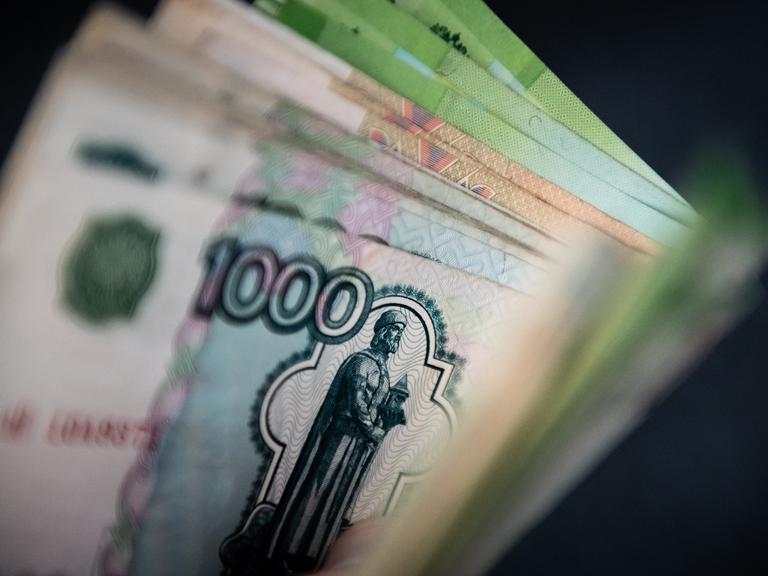 Ein Mann hält Rubelscheine in der Hand