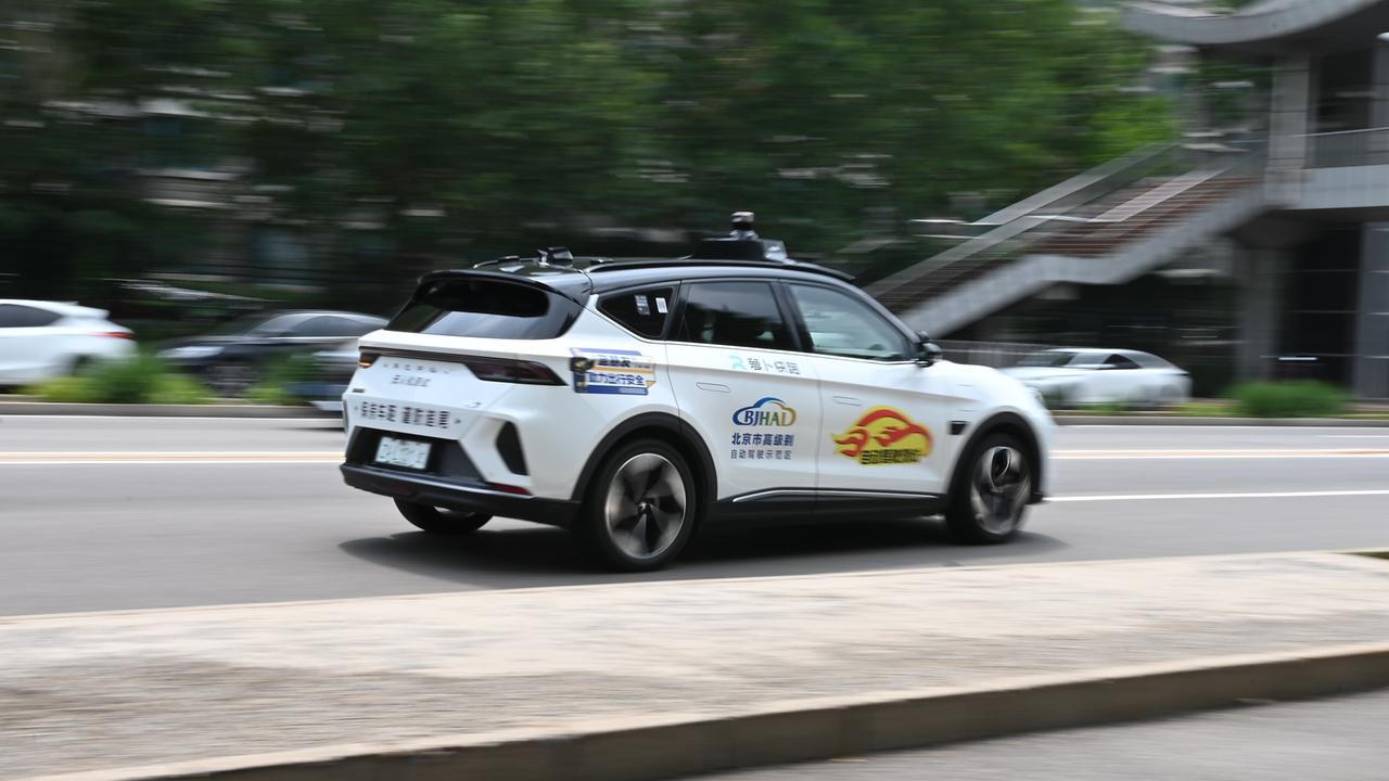 Ein autonom fahrendes Taxi des Anbieters Apollo Go fährt auf der Straße.