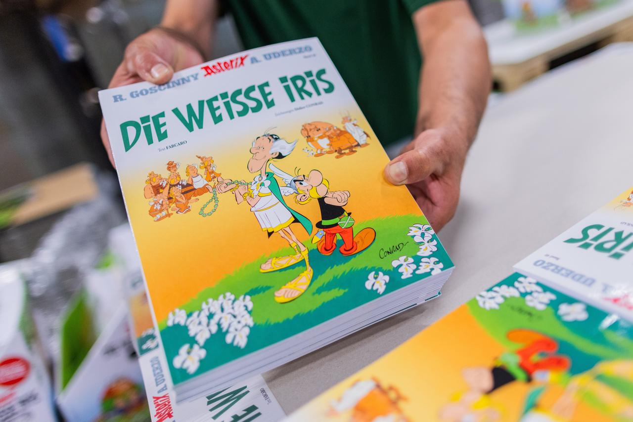 Zwei Hände halten Ausgaben des Asterix-Bandes "Die weiße Iris"
