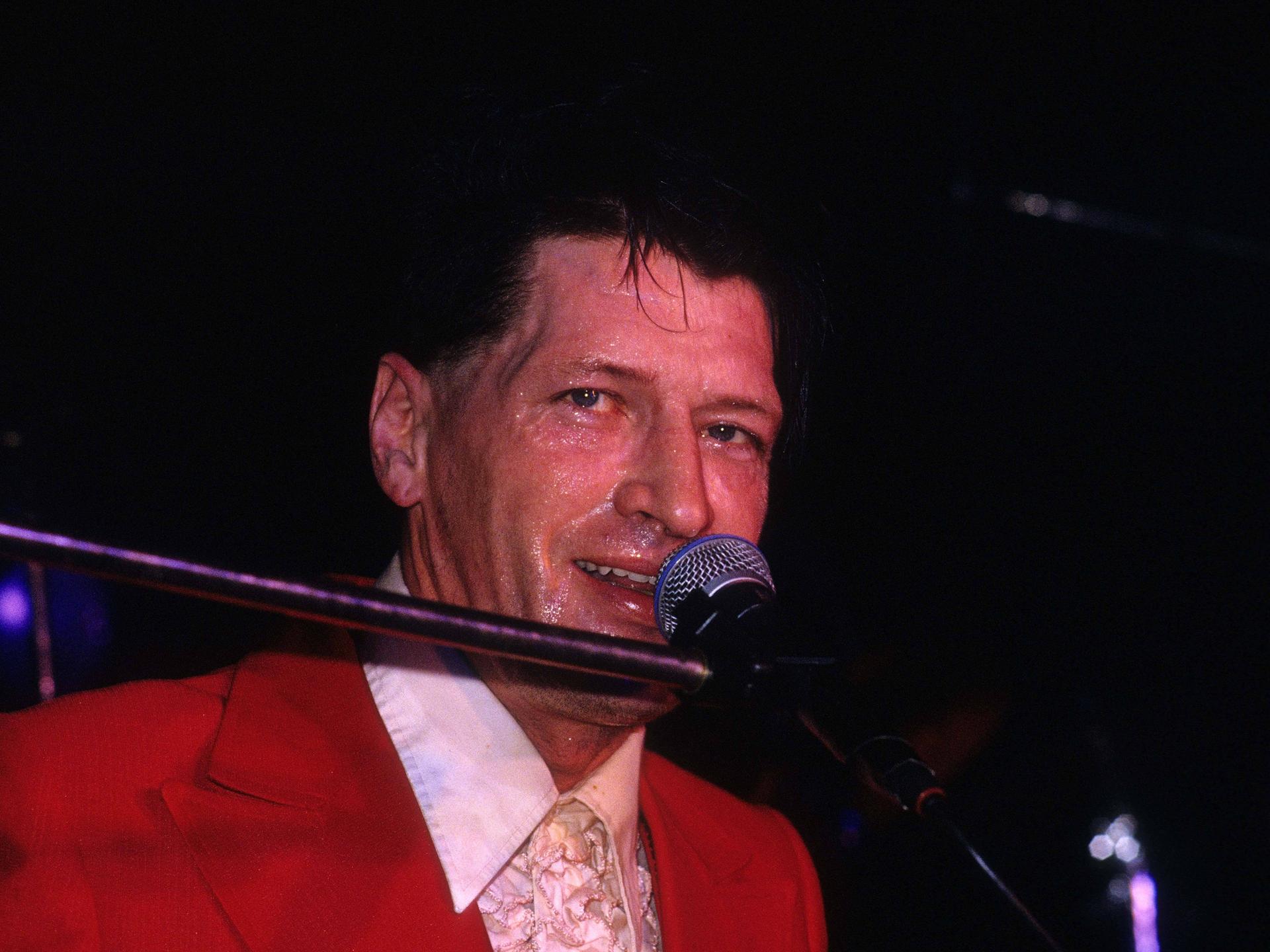 Herman Brood lächelnd am Mikrofon