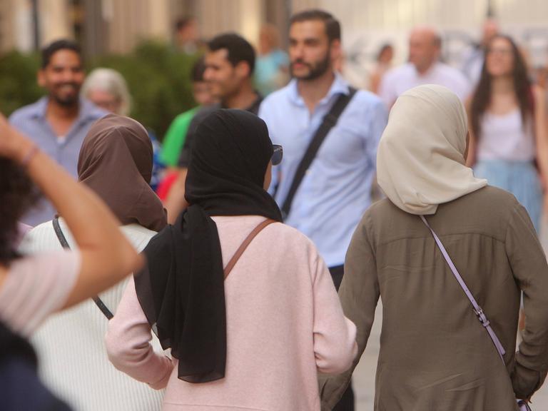 Muslima mit Burkas und Kopftüchern spazieren in der Innenstadt München.
