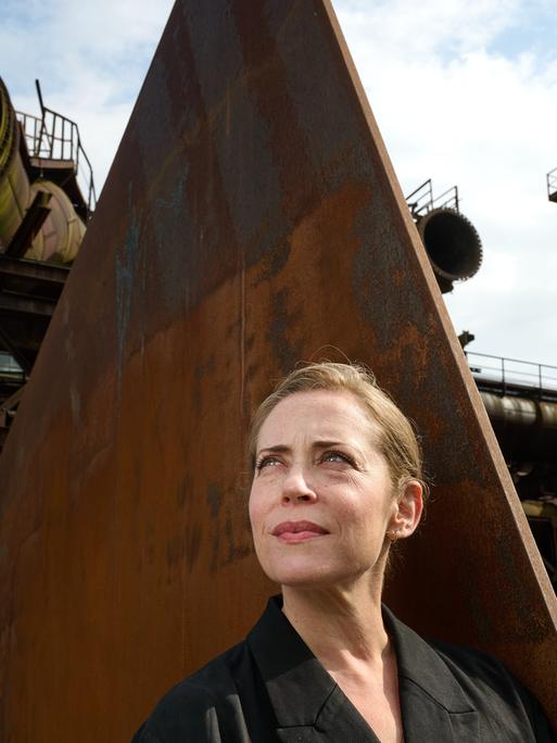 Lydia Steier, Intendantin der Ruhrtriennale ab 2027, steht in der Jahrhunderthalle vor einer Eisenskulptur