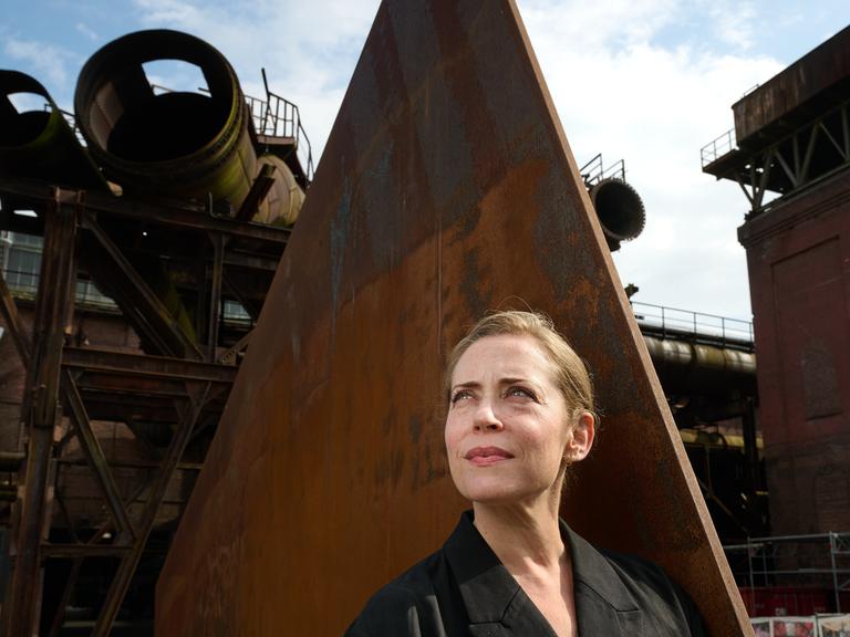 Lydia Steier, Intendantin der Ruhrtriennale ab 2027, steht in der Jahrhunderthalle vor einer Eisenskulptur
