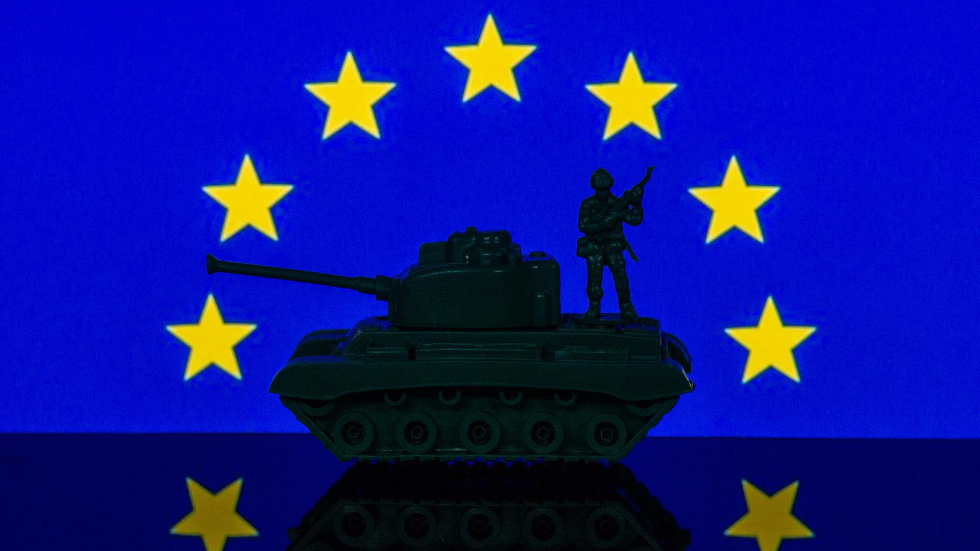 Eine Panzerattrappe steht unter dem Sternenrund der EU-Flagge