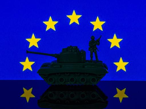 Eine Panzerattrappe steht unter dem Sternenrund der EU-Flagge