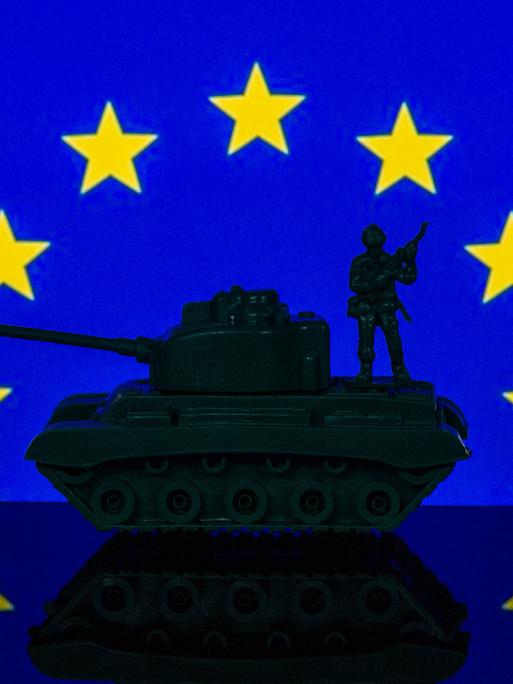 Eine Panzerattrappe steht unter dem Sternenrund der EU-Flagge