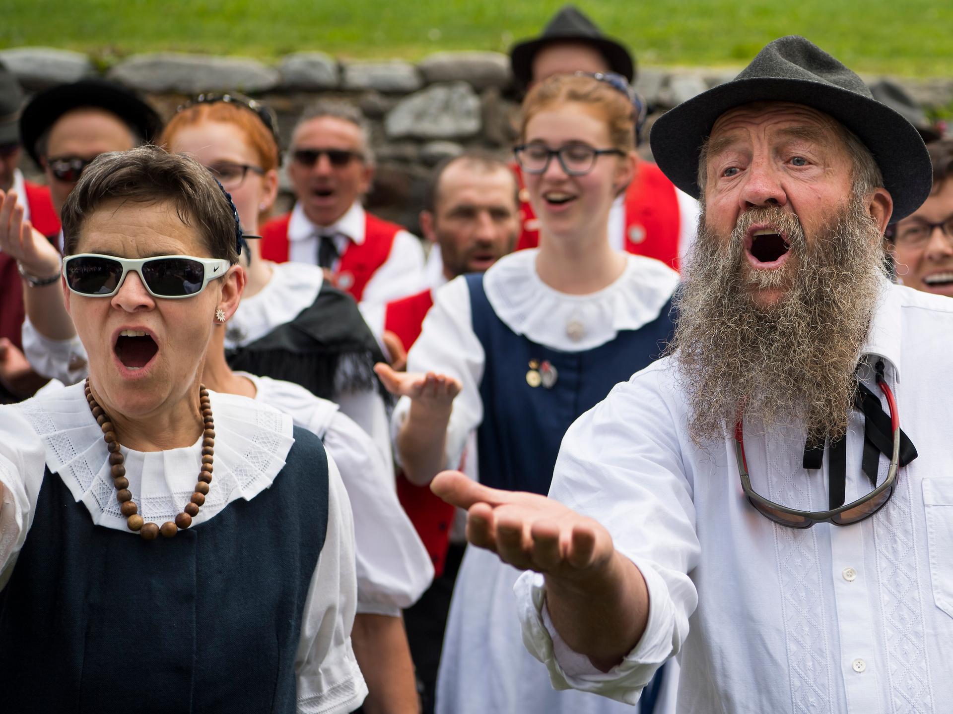 Eine Gruppe von Männern und Frauen in Tracht jodelt