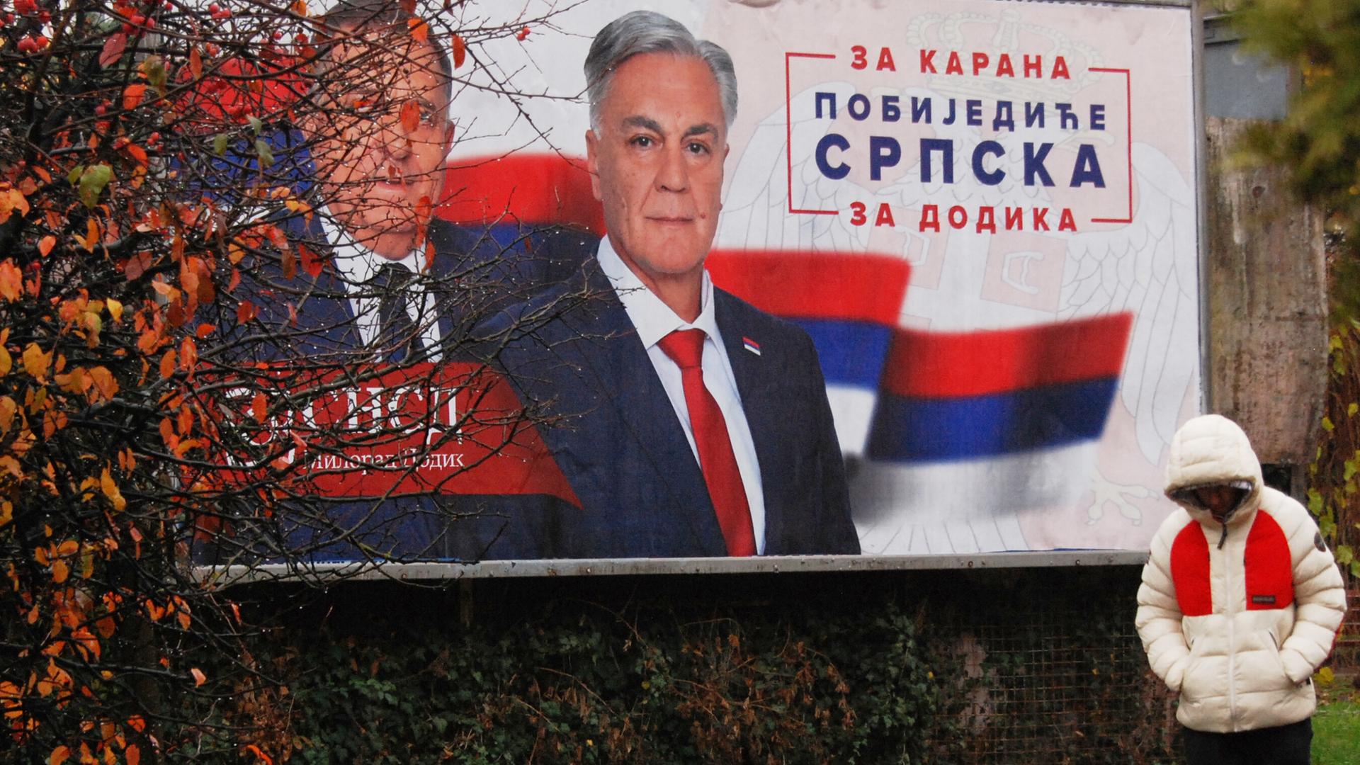 Wahlkampf im Landesteil Republika Srpska in Bosnien-Herzegowina: Eine Person läuft an einem Plakat vorbei.