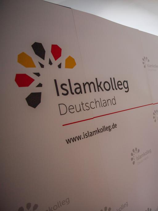 Ein Raum mit einem Flipboard und mehreren Menschen bei der Eröffnung des Islam-Kollegs in Osnabrück
