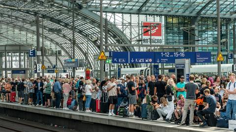 Reisende auf dem Berliner Hauptbahnhof drängeln sich auf einem Bahnsteig und warten auf den Zug.