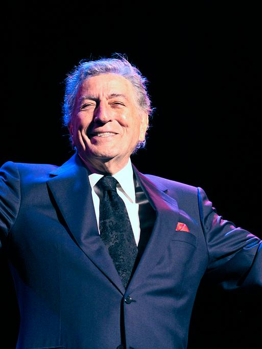 US-Sänger Tony Bennett strahlt bei einme Konzert in Kopenhagen im Jahr 2011 und hält die Arme hoch 