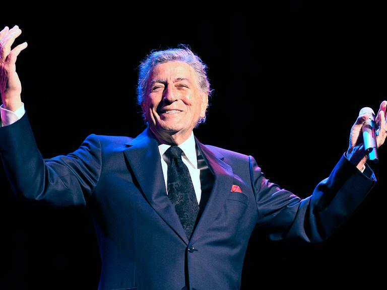 US-Sänger Tony Bennett strahlt bei einme Konzert in Kopenhagen im Jahr 2011 und hält die Arme hoch 