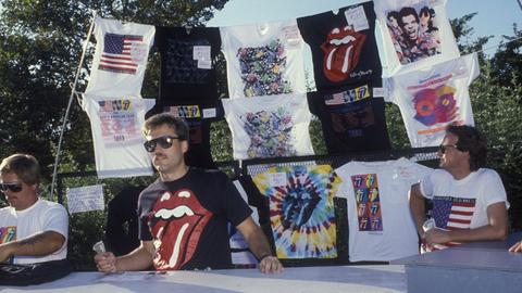 Merchandise-Stand mit Band-Shirts unter anderem mit der ikonischen Zunge der Rolling Stones auf einer Konzert-Tournee 1989 in den USA. 