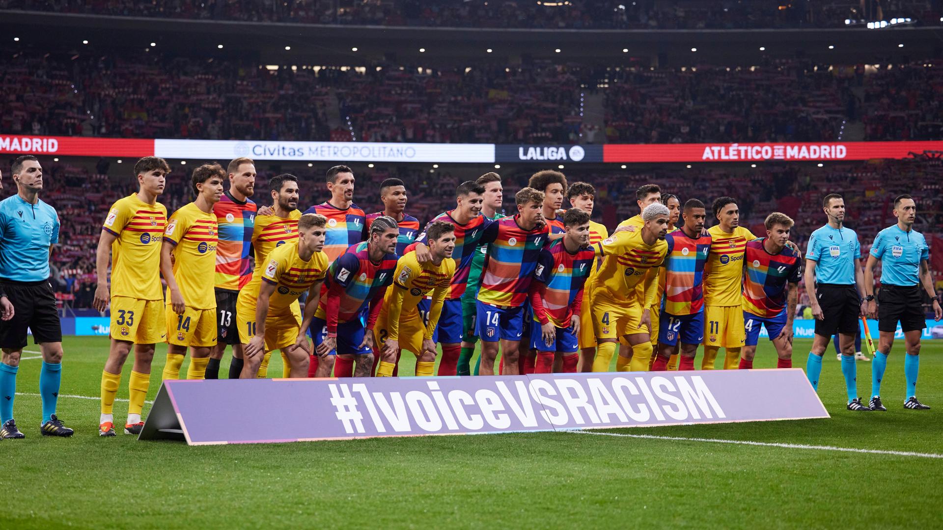 Spieler des FC Barcelona und von Atletico Madrid posieren vor einem Anti-Rassismus-Banner.