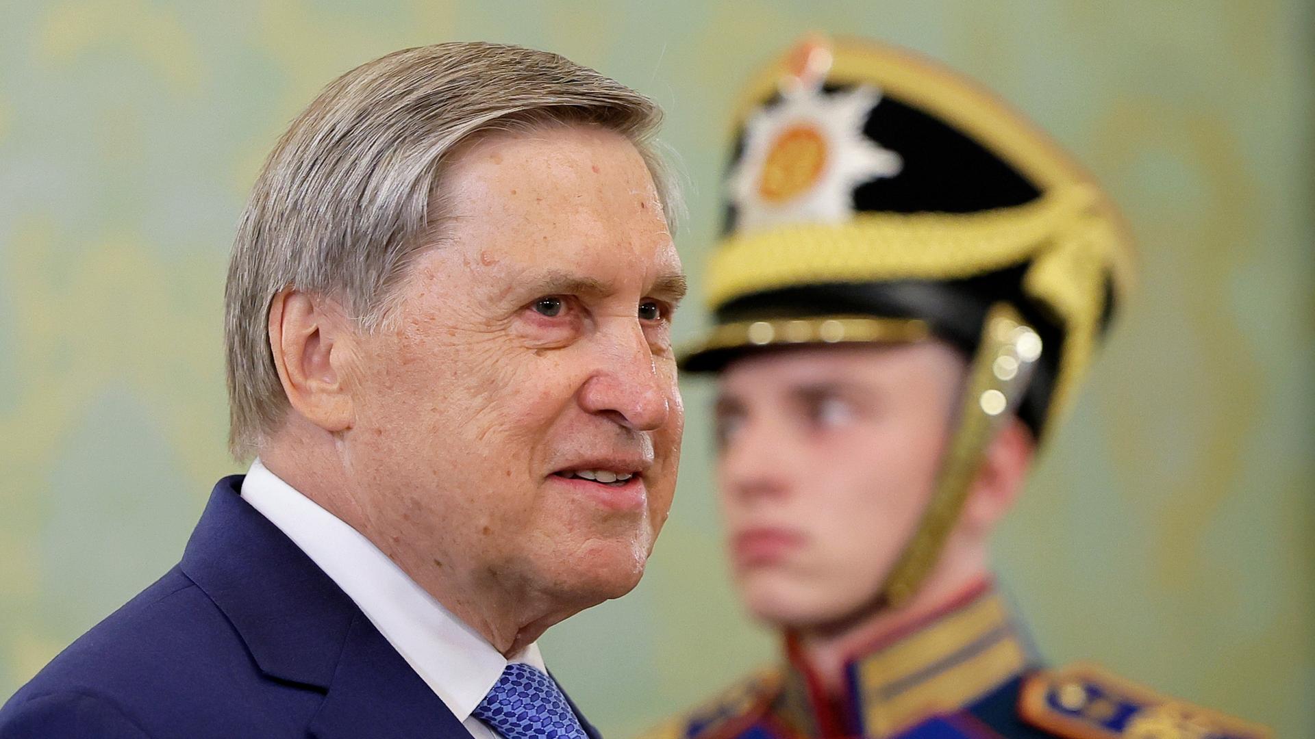 Juri Uschakow, Berater des russischen Präsidenten Wladimir Putin, steht vor einem jungen Soldaten. 