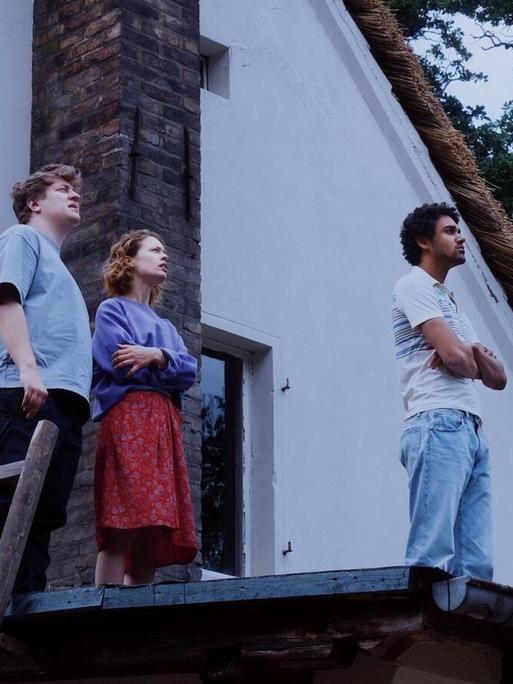 In der Filmszene aus dem "Roter Himmel" stehen die vier Hauptdarsteller auf einem Hausdach und schauen in den Himmel.
