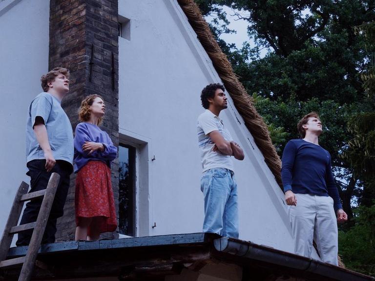 In der Filmszene aus dem "Roter Himmel" stehen die vier Hauptdarsteller auf einem Hausdach und schauen in den Himmel.