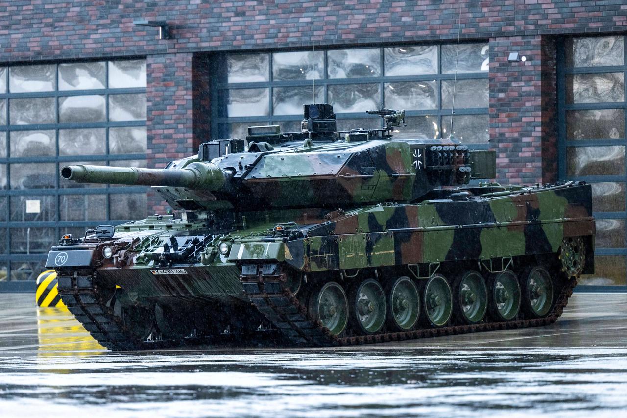 Vor einer Garagenhalle steht ein Leopard 2 Panzer der Bundeswehr.