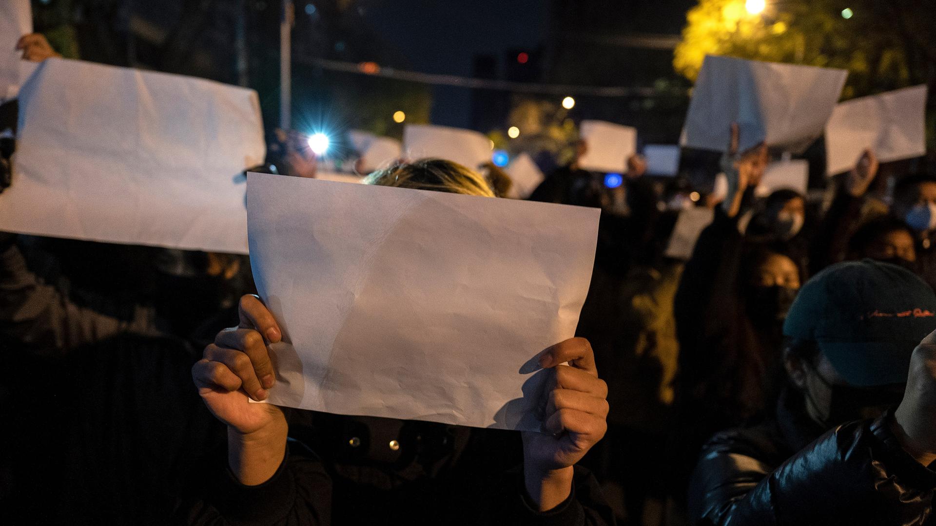 In Peking halten Menschen leere weiße Papiere in die Höhe. Der Protest richtet sich gegen die Regierung.