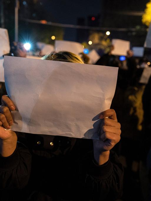 In Peking halten Menschen leere weiße Papiere in die Höhe. Der Protest richtet sich gegen die Regierung.