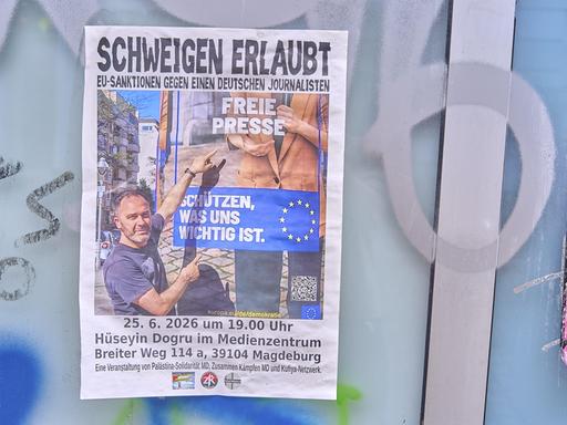 An einer Wand hängt ein Plakat mit der Aufschrift "Schweigen erlaubt - EU-Sanktionen gegen einen deutschen Journalisten".