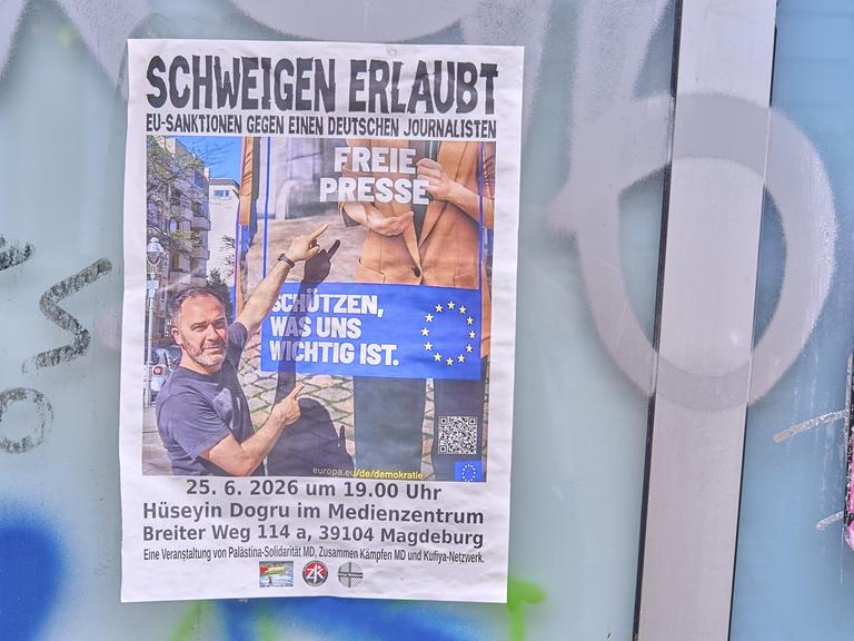 An einer Wand hängt ein Plakat mit der Aufschrift "Schweigen erlaubt - EU-Sanktionen gegen einen deutschen Journalisten".