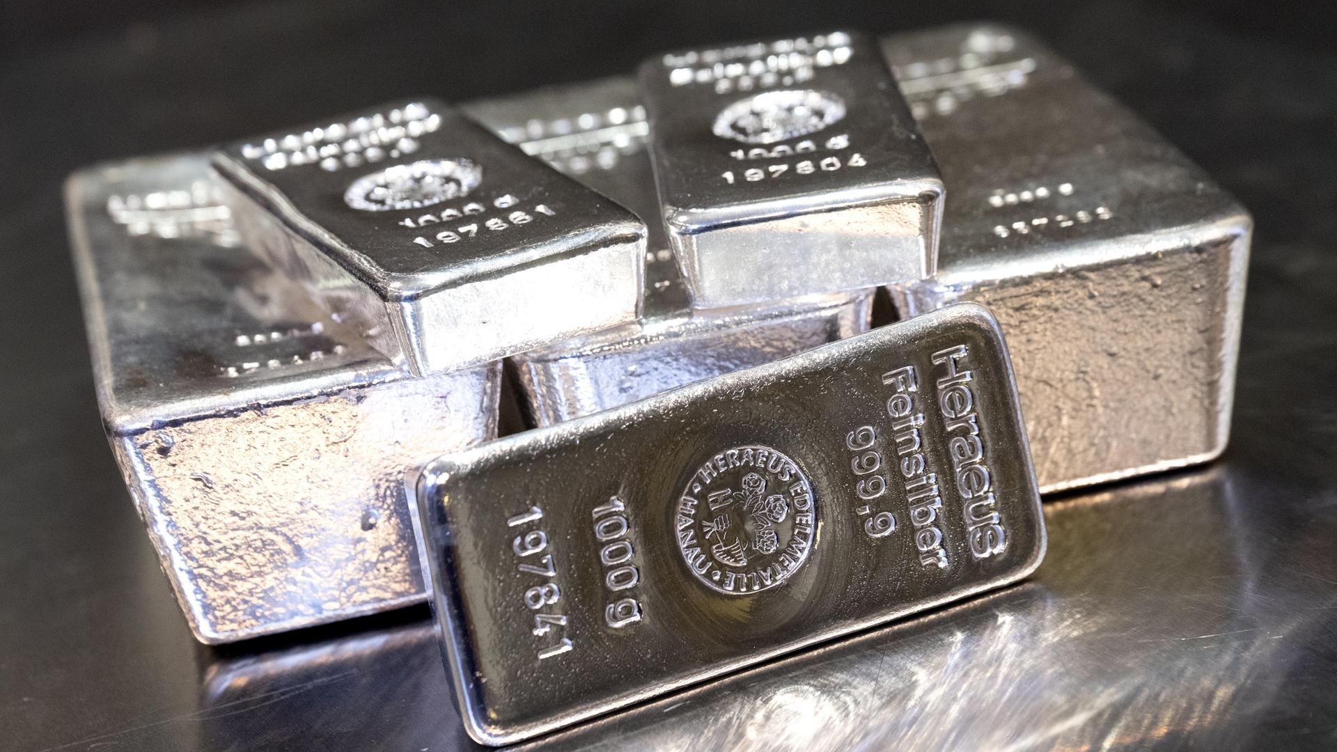 Silberbarren in unterschiedlicher Größe liegen auf einem Tisch. Silberbarren in unterschiedlicher Größe liegen auf einem Tisch.