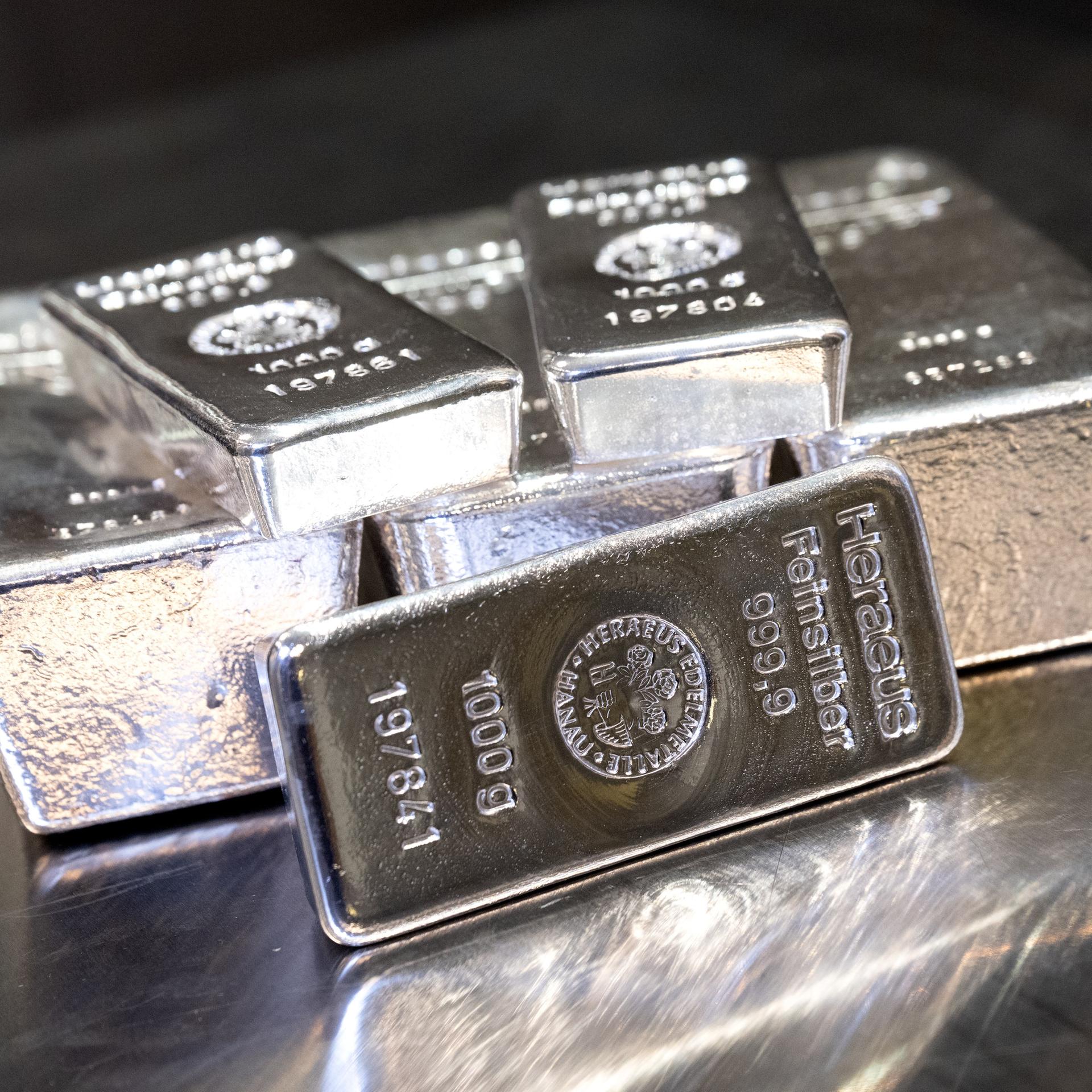 Silberbarren in unterschiedlicher Größe liegen auf einem Tisch.