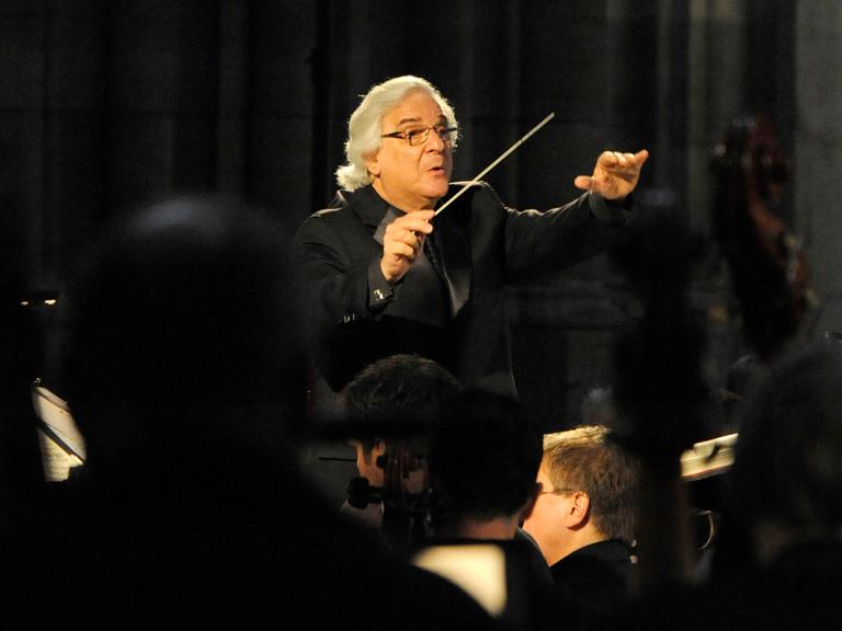 Der US-Dirigent Murry Sidlin steht vor einem Orchester und dirigiert.