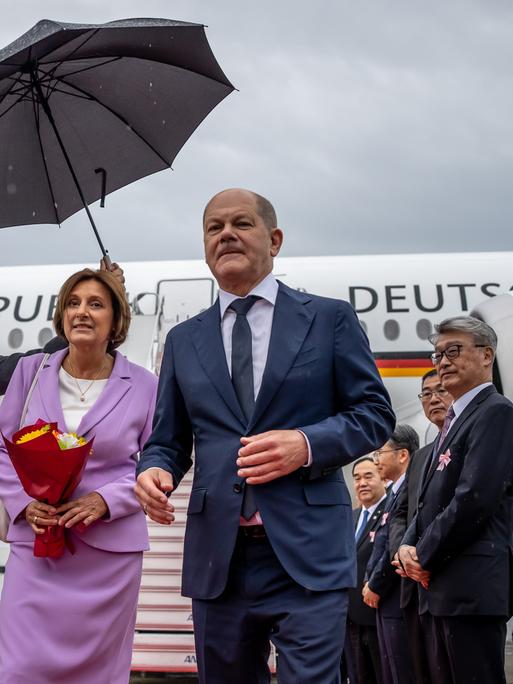Bundeskanzler Olaf Scholz und seine Frau Britta Ernst verlassen das deutsche Flugzeug über die Gangway am Flughafen von Hiroshima.