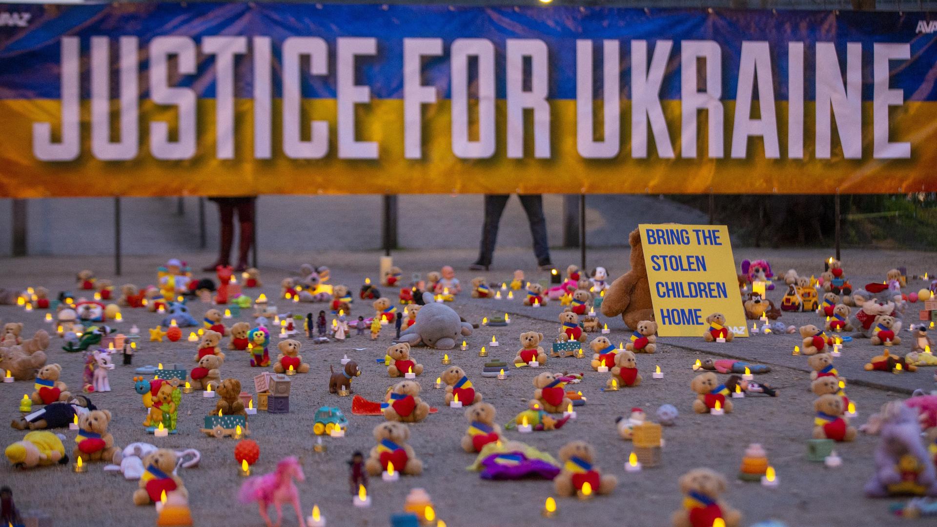 Die Abbildung zeigt eine symbolische Aktion unter der Leitung von Avaaz-Mitgliedern und ukrainischen Flüchtlingen mit der Hinterlegung Tausender Teddybären und Spielzeugen als Symbol für die Tausenden Kinder, die im Krieg in der Ukraine entführt wurden.