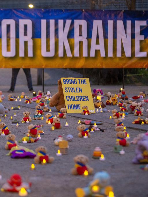 Die Abbildung zeigt eine symbolische Aktion unter der Leitung von Avaaz-Mitgliedern und ukrainischen Flüchtlingen mit der Hinterlegung Tausender Teddybären und Spielzeugen als Symbol für die Tausenden Kinder, die im Krieg in der Ukraine entführt wurden.