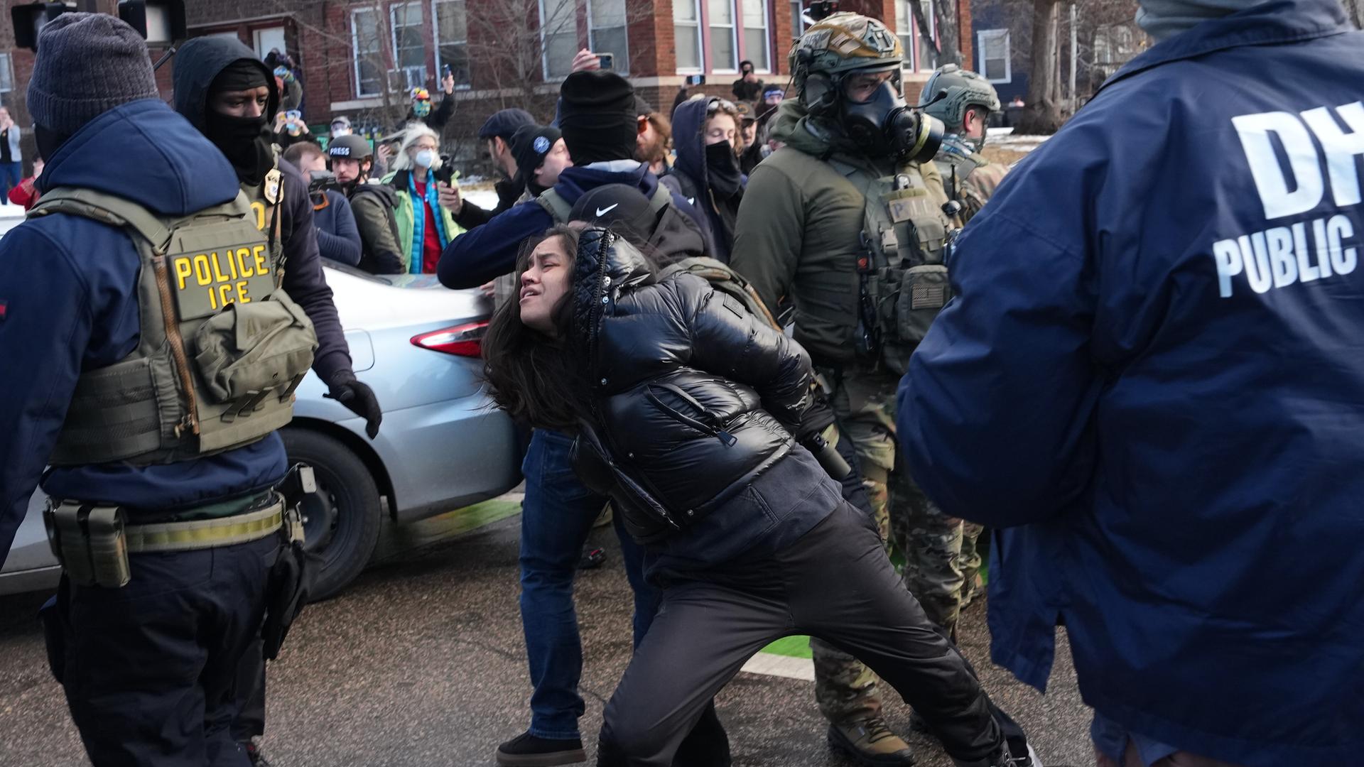 Eine Frau in Minneapolis wird von Beamten der US-Migrationsbehörde ICE festgehalten.