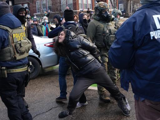 Eine Frau in Minneapolis wird von Beamten der US-Migrationsbehörde ICE festgehalten. Eine Frau in Minneapolis wird von Beamten der US-Migrationsbehörde ICE festgehalten.