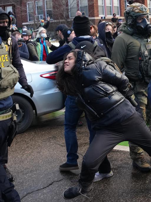 Eine Frau in Minneapolis wird von Beamten der US-Migrationsbehörde ICE festgehalten. Eine Frau in Minneapolis wird von Beamten der US-Migrationsbehörde ICE festgehalten.