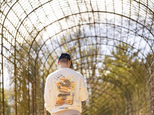 Ein Mann geht durch einen Gittertunnel im Park Ein Mann geht durch einen Gittertunnel im Park